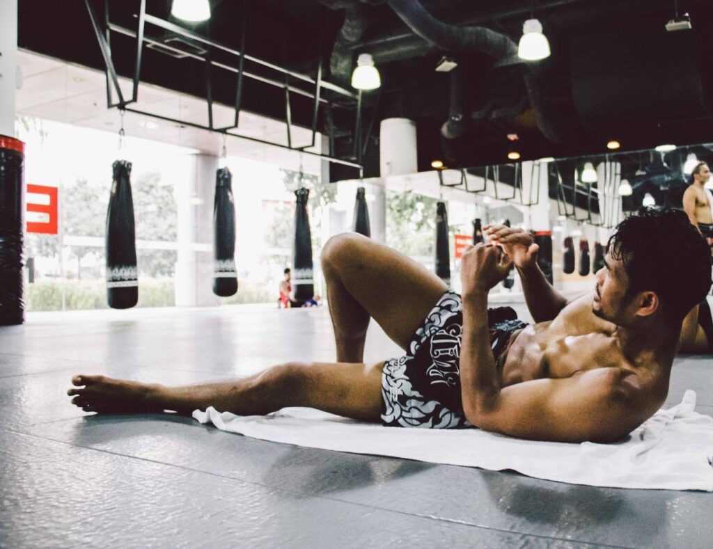 Boxing World Champion Yodsanan Sityodtong works on his core after a tough training session with the Evolve Fight Team.
