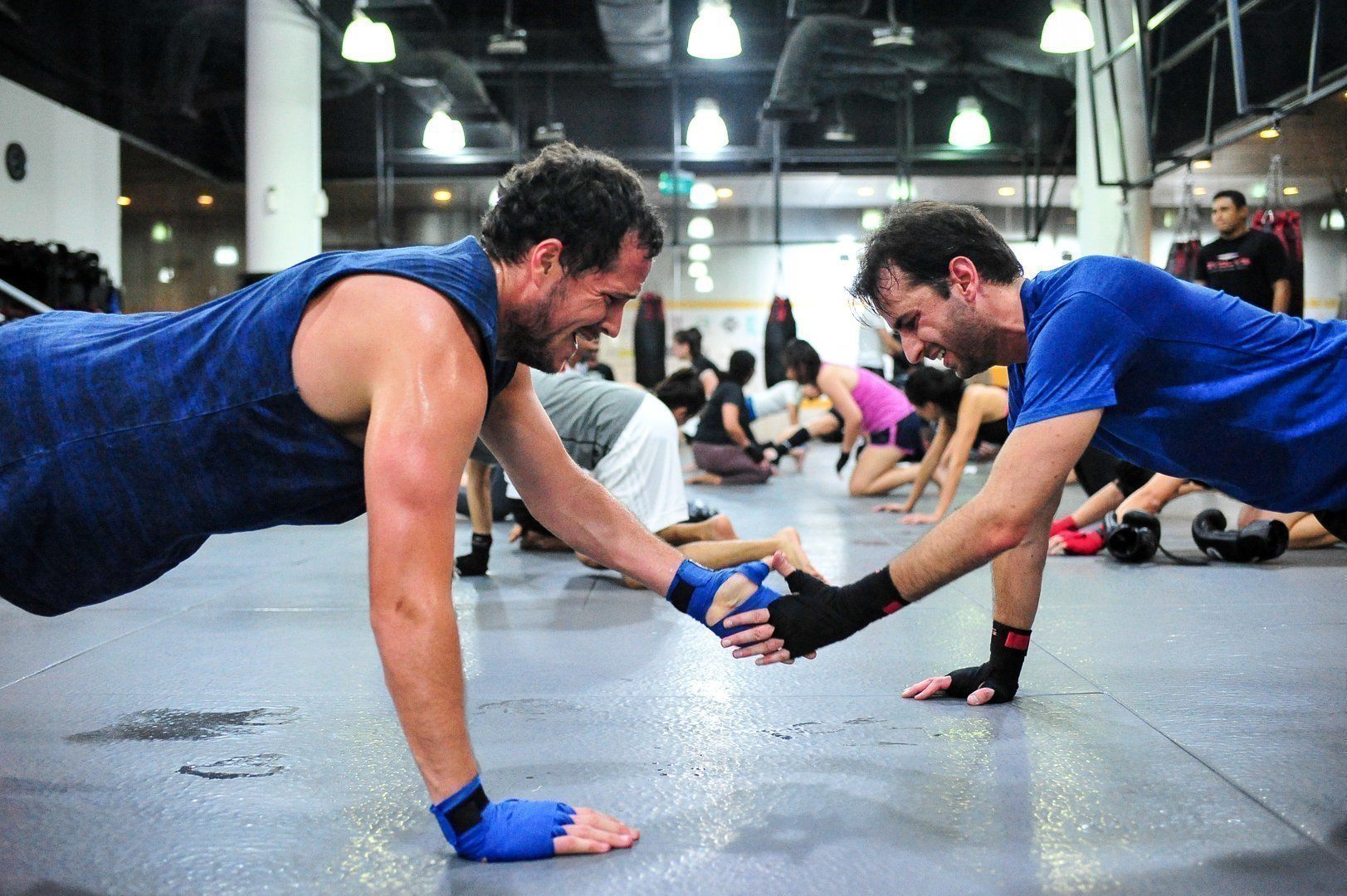 Two students doing push-ups during a Muay Thai class.