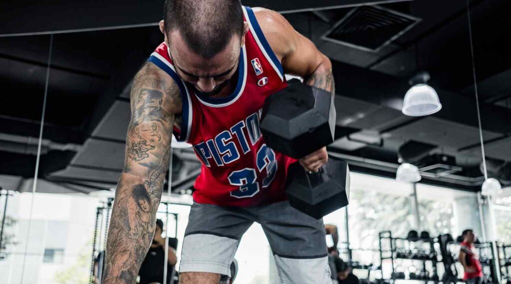 a person performing a one handed dumbbell row