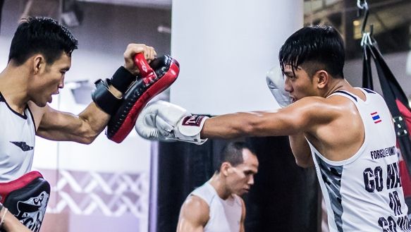 A Muay Thai student throws a jab at the pads.