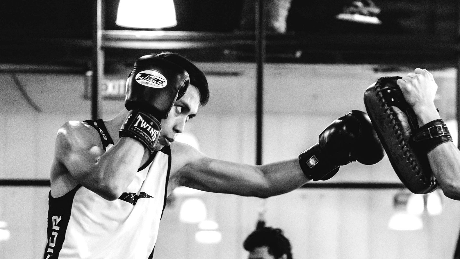 A Muay Thai fighters hits the pads in a class.