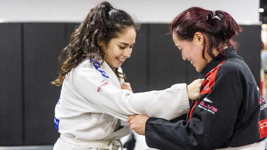 Two female BJJ students training in class