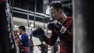 Sam-A training Muay Thai on a heavy bag.