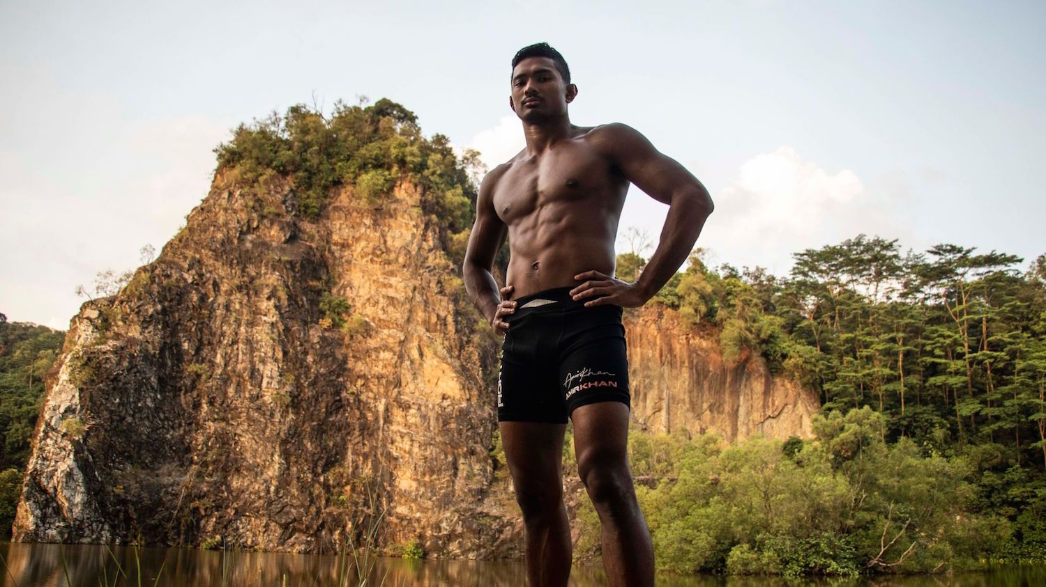 Amir Khan standing in front of a mountain