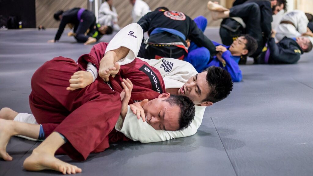 Two BJJ students rolling in the gym