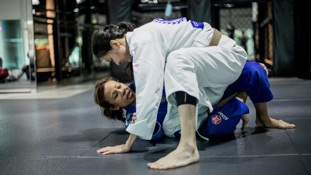 two female students rolling in bjj