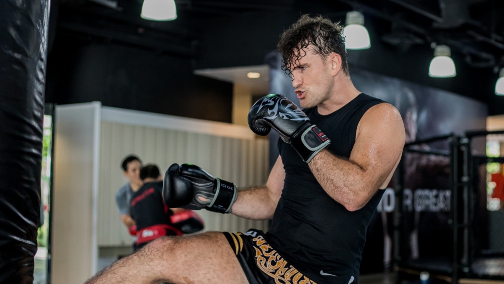 student kicking heavy bag