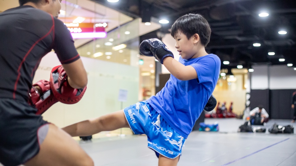 boy doing padwork in muay thai kids