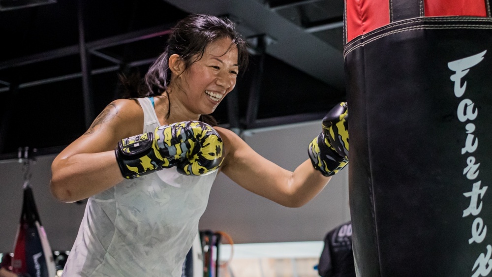 happy student punching heavy bag