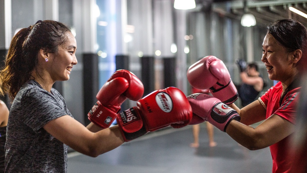 happy students fist bumping with boxing glove